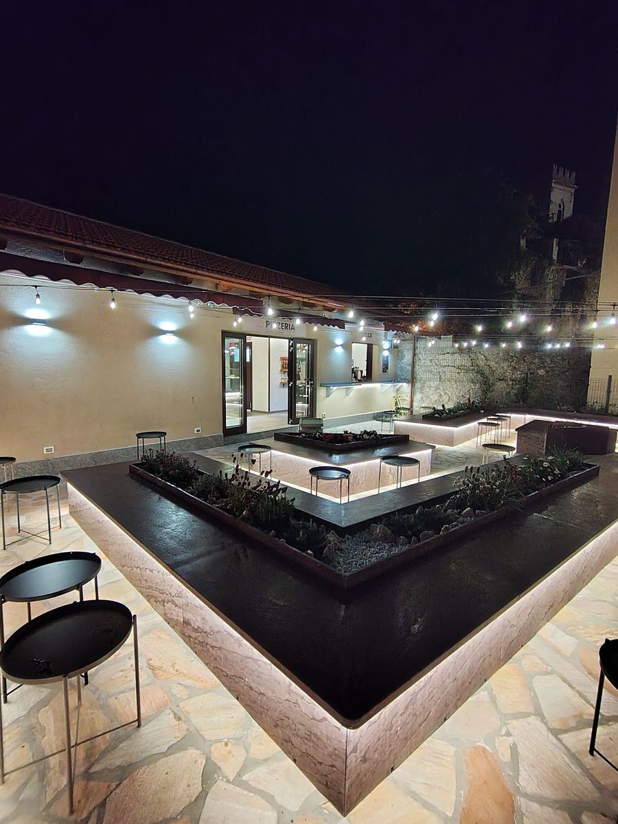 Il cortile di sera, con le panche e le luci accese