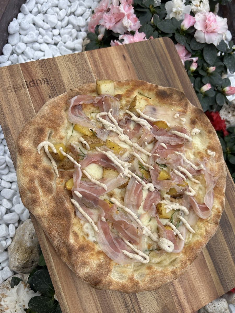Una pizza appena uscita dal forno, sul tagliere