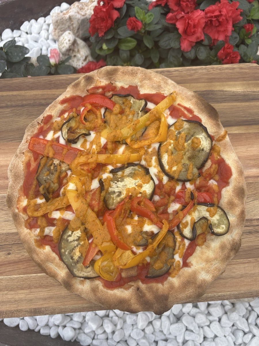 Una pizza alle verdure sul tagliere